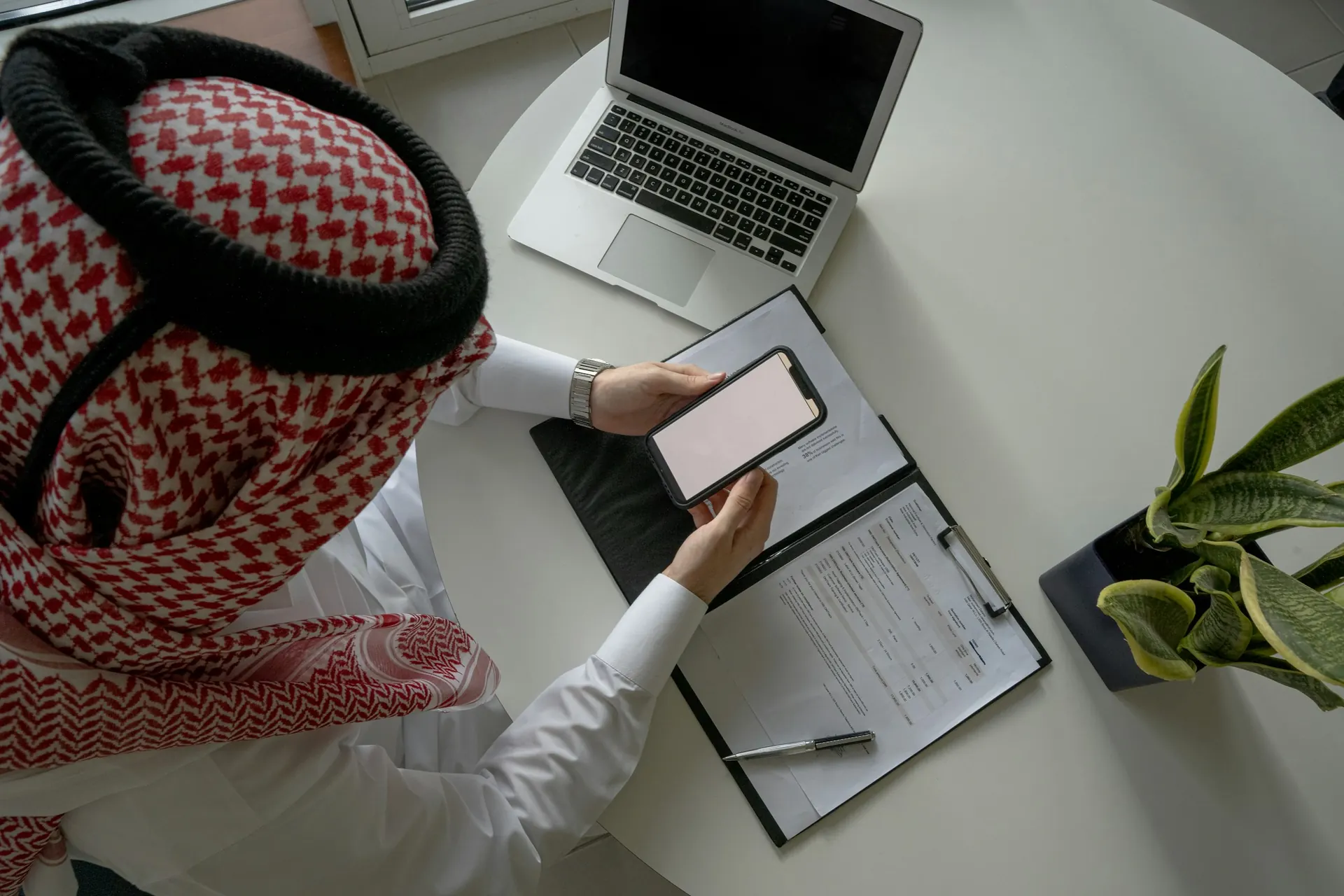 طالب سعودي يراجع ملاحظاته أمام حاسوب محمول استعدادًا لاختبار قبول